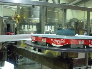 Получив фирменную наклейку, бутылки продолжают свой путь - отправляются на упаковку.
