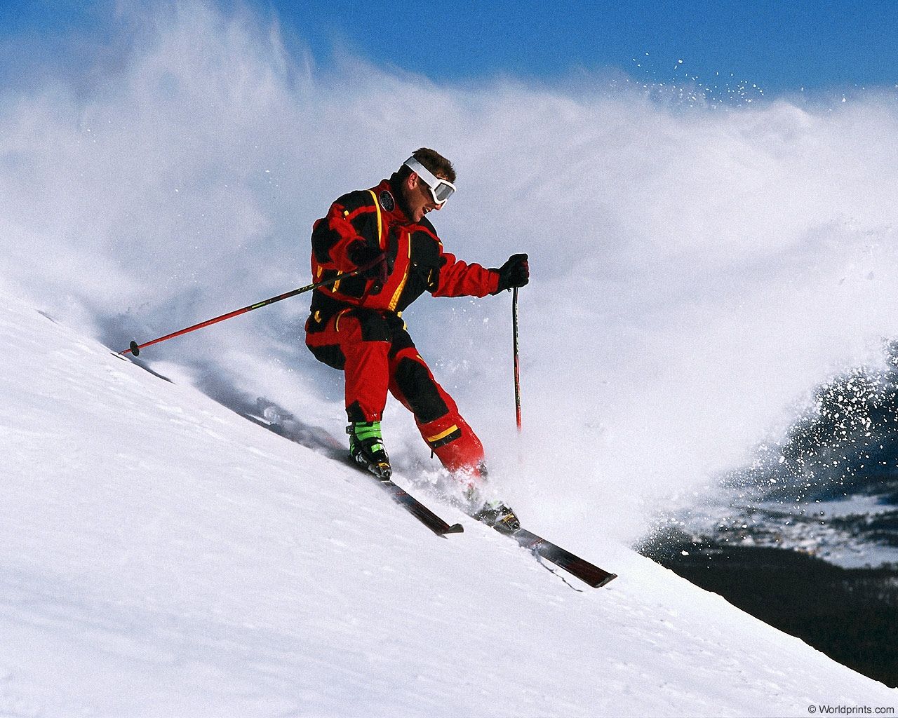 Лыжник скатывается. Горнолыжный спорт. Спуск с горы на лыжах. Лыжник спускается с горы.
